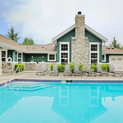 Shimmering resort-style pool a swimming pool in front of a house