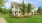 a large house with a lawn and trees in front of it