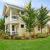 a large house with a lawn and trees in front of it