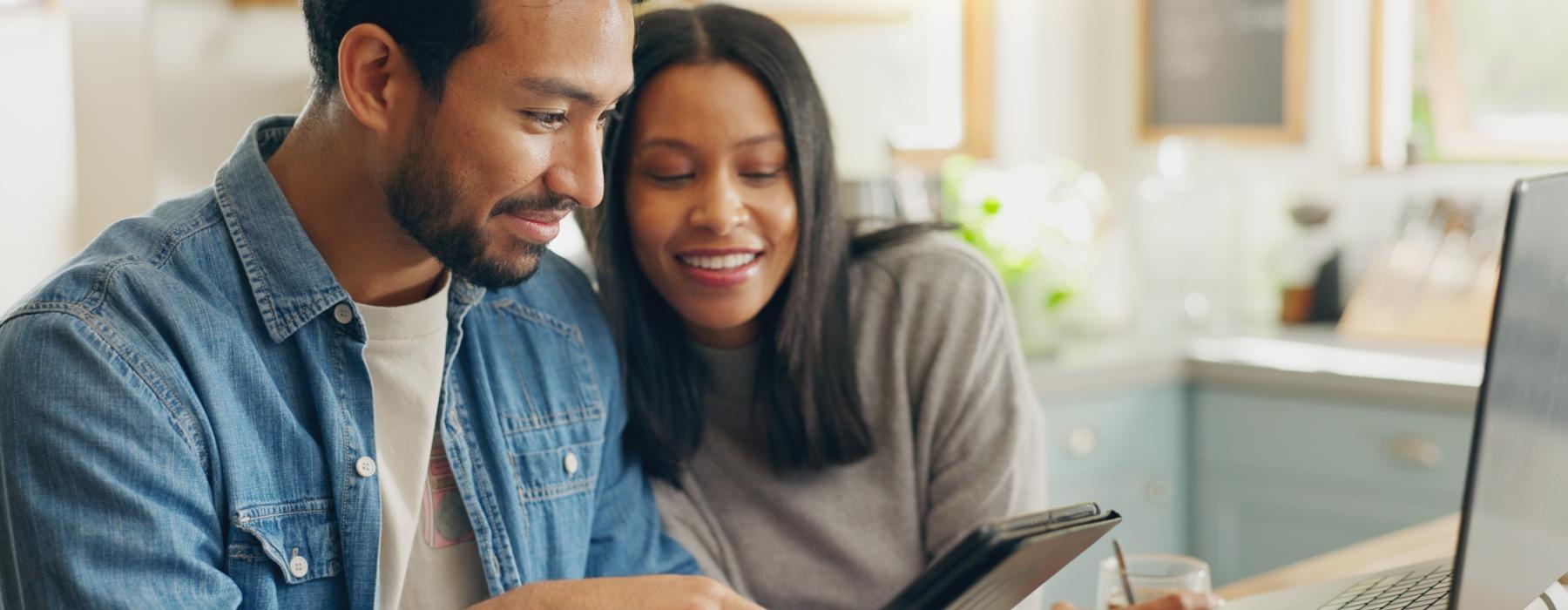 a man and a woman looking at a laptop