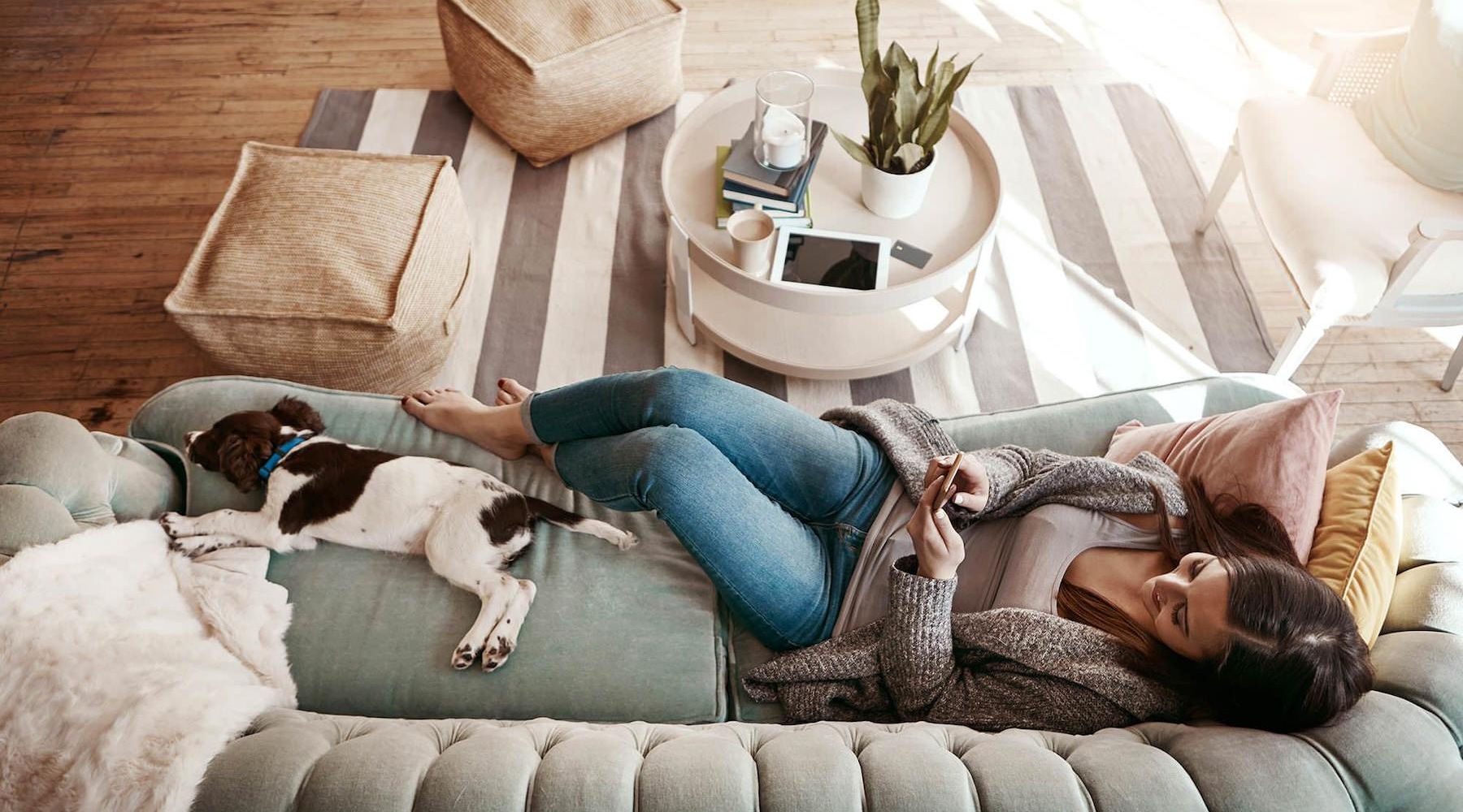 a woman and a dog laying down on a couch a woman and a dog laying down on a couch in a living room